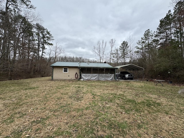 view of front of house featuring a detached carport, metal roof, and a front yard