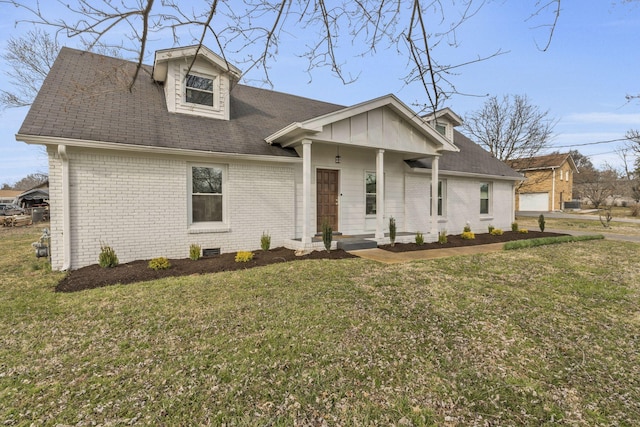 view of front of home featuring brick siding, a front lawn, and a porch