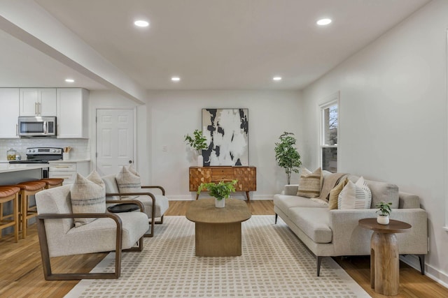 living room featuring light wood-style floors, baseboards, and recessed lighting