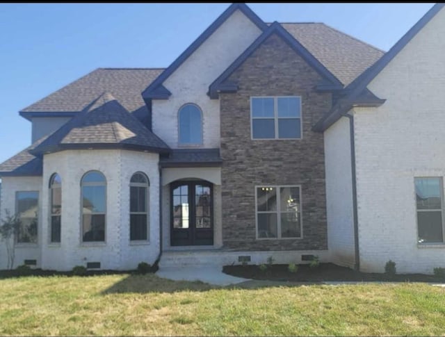 french country home with a front lawn, crawl space, roof with shingles, and french doors