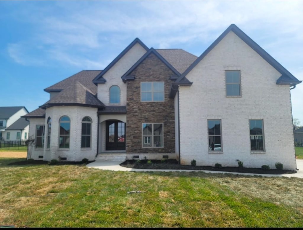 view of front of home with brick siding, french doors, crawl space, roof with shingles, and a front lawn