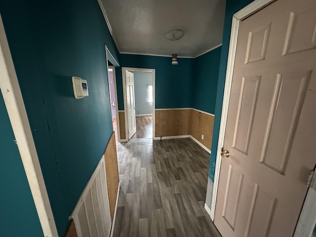 hall featuring dark wood-style floors, a wainscoted wall, and visible vents