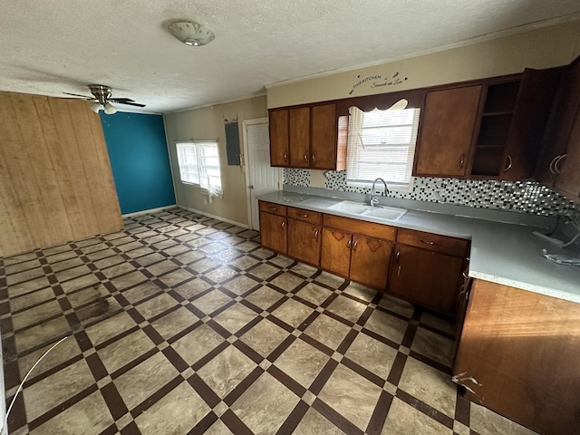 kitchen featuring light countertops, a sink, a textured ceiling, and open shelves