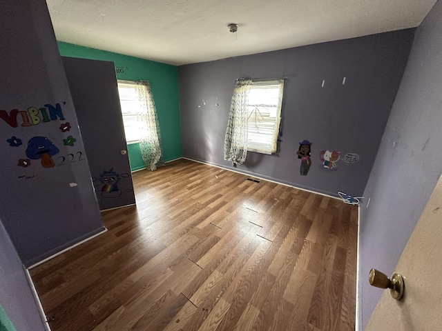 interior space featuring plenty of natural light, wood finished floors, and visible vents