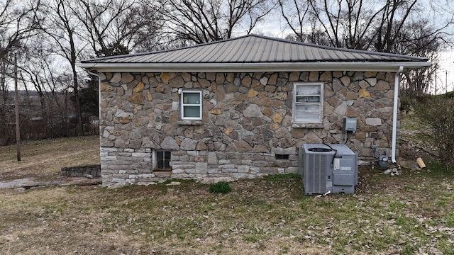 view of property exterior with metal roof, central AC unit, and crawl space