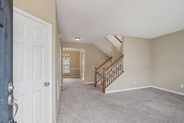 foyer featuring baseboards, carpet, stairway, and a notable chandelier