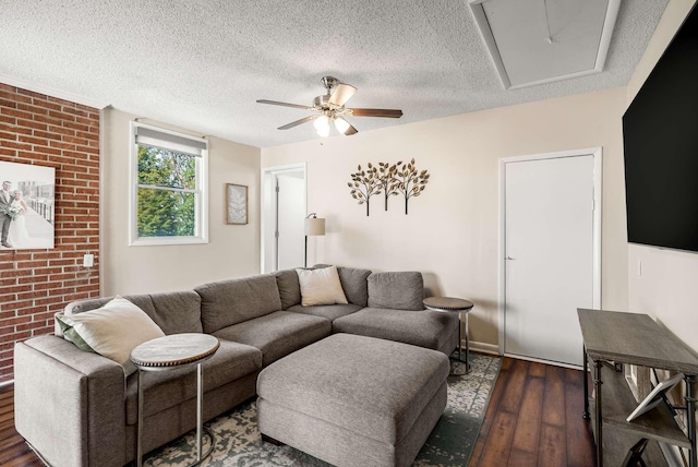 living room featuring a ceiling fan, a textured ceiling, brick wall, and hardwood / wood-style flooring