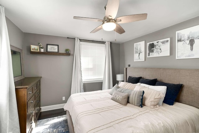 bedroom with dark wood-style floors, ceiling fan, and baseboards