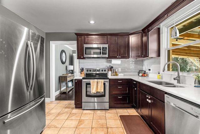 kitchen featuring appliances with stainless steel finishes, decorative backsplash, a sink, and light countertops