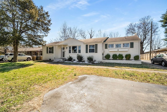 ranch-style house featuring a front yard and brick siding