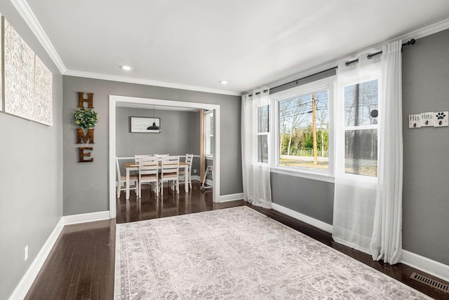 unfurnished dining area with baseboards, visible vents, dark wood-style flooring, and ornamental molding