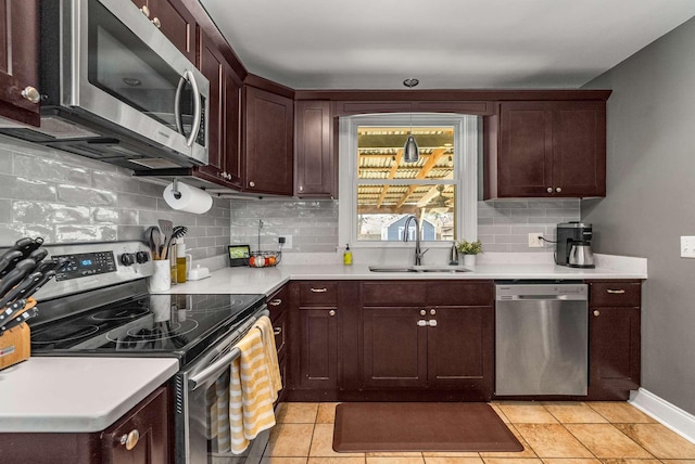 kitchen featuring appliances with stainless steel finishes, decorative backsplash, a sink, and light countertops