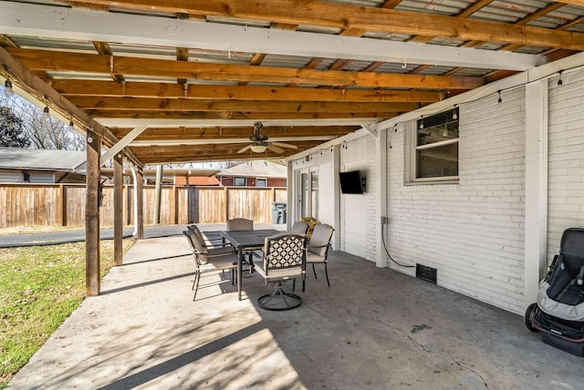 view of patio featuring a ceiling fan, outdoor dining space, and fence