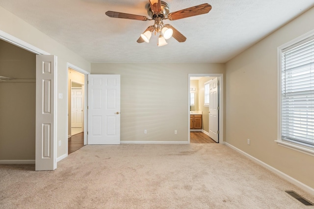 unfurnished bedroom with baseboards, visible vents, a textured ceiling, carpet floors, and a closet