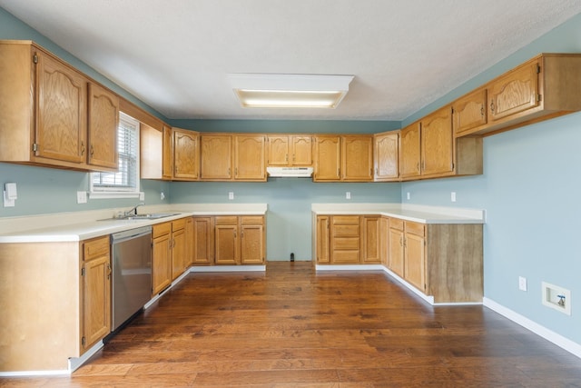 kitchen with dark wood-type flooring, a sink, dishwasher, under cabinet range hood, and baseboards