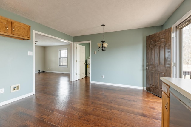 interior space featuring a textured ceiling, electric water heater, baseboards, dark wood-style floors, and an inviting chandelier