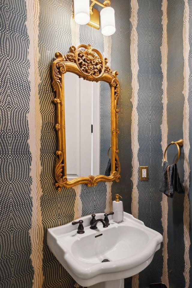 bathroom with a sink and wallpapered walls