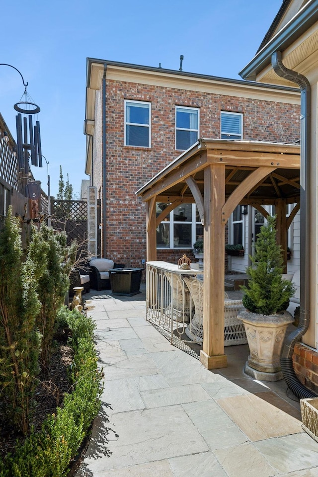 rear view of property with a patio area and brick siding