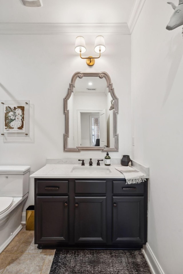 bathroom featuring toilet, baseboards, ornamental molding, and vanity