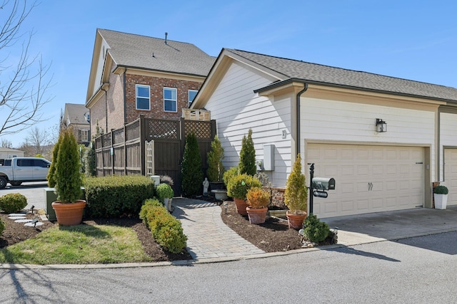 view of front facade with concrete driveway and a shingled roof