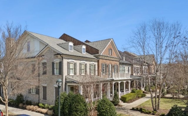 view of front facade featuring a balcony and brick siding