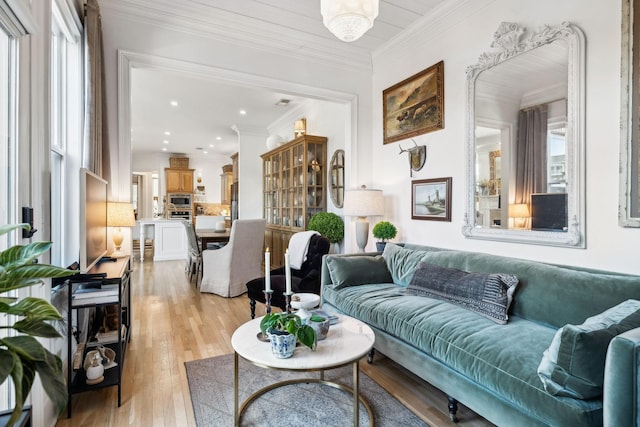 living room featuring light wood-type flooring, crown molding, and recessed lighting