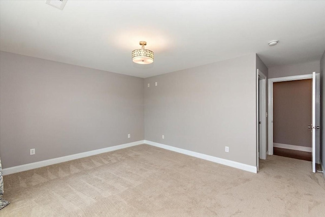 unfurnished room with light carpet, visible vents, and baseboards