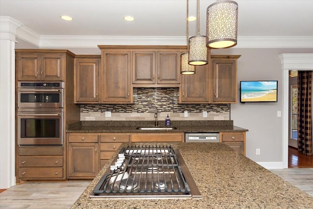 kitchen featuring light wood-style floors, ornamental molding, stainless steel appliances, and a sink