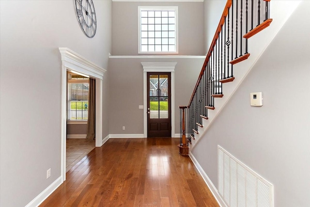 entryway with a healthy amount of sunlight, hardwood / wood-style flooring, baseboards, and visible vents