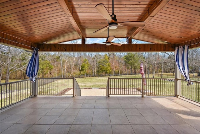 unfurnished sunroom featuring a wealth of natural light, wooden ceiling, vaulted ceiling with beams, and ceiling fan