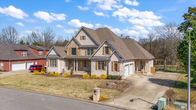 view of front facade with driveway, a garage, stone siding, roof with shingles, and a front yard