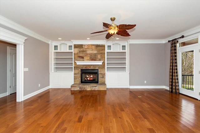 unfurnished living room featuring a fireplace, ornamental molding, ceiling fan, wood finished floors, and baseboards