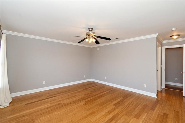 spare room featuring light wood-style floors, ornamental molding, baseboards, and a ceiling fan