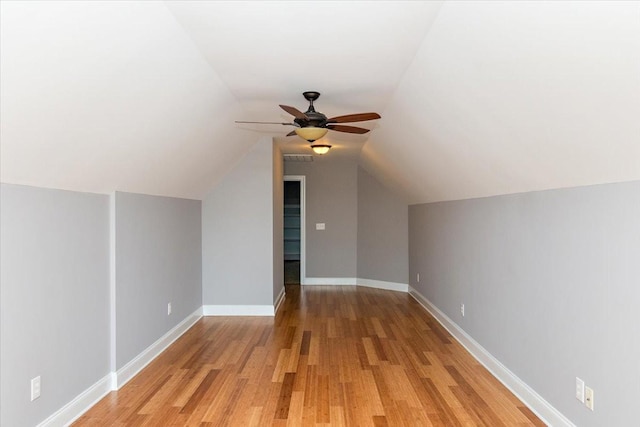 bonus room with lofted ceiling, light wood finished floors, baseboards, and a ceiling fan