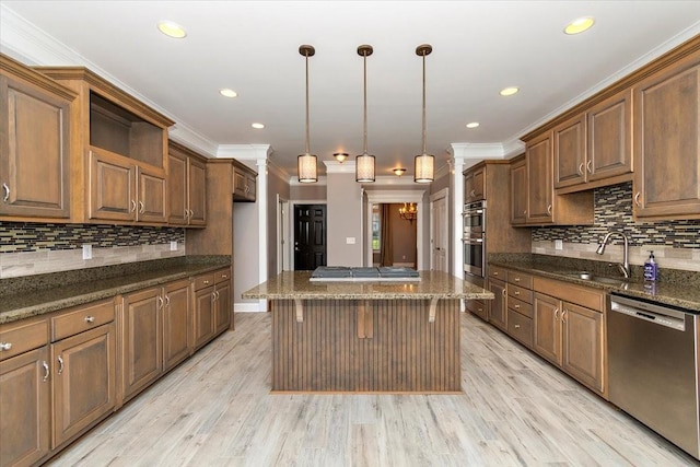 kitchen featuring crown molding, stainless steel appliances, light wood-style floors, a sink, and a kitchen island