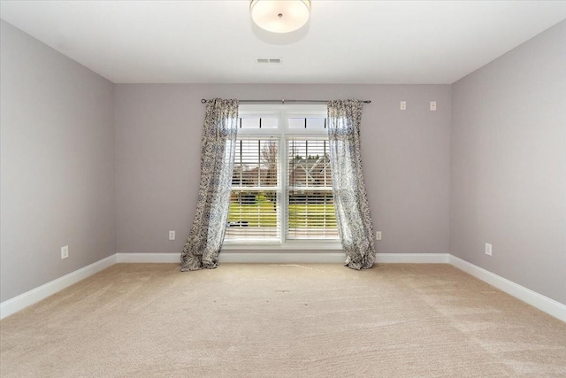 unfurnished room with carpet floors, visible vents, and baseboards