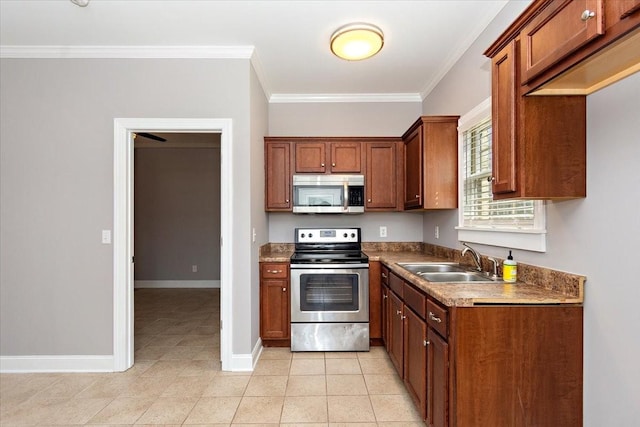 kitchen featuring ornamental molding, appliances with stainless steel finishes, a sink, and baseboards