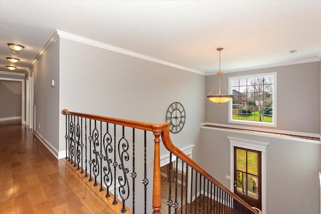 hall with an upstairs landing, baseboards, plenty of natural light, and hardwood / wood-style floors