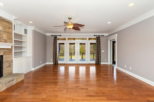 unfurnished living room featuring baseboards, ornamental molding, a fireplace, and light wood-style floors