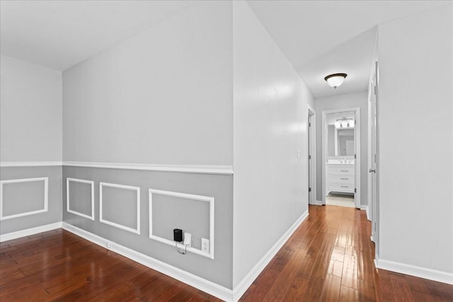 hallway with hardwood / wood-style flooring and baseboards