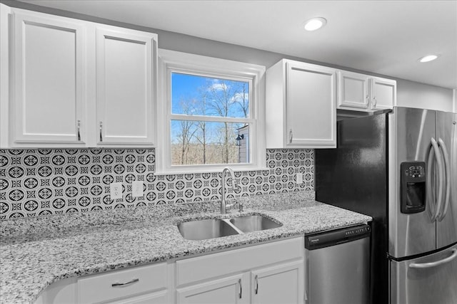 kitchen with tasteful backsplash, recessed lighting, appliances with stainless steel finishes, white cabinets, and a sink