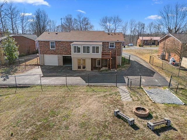 back of house featuring fence private yard, aphalt driveway, and brick siding