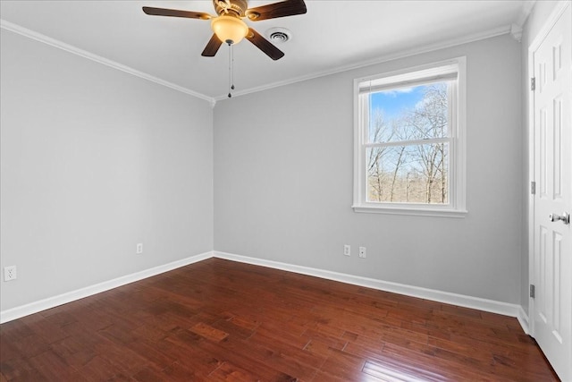 empty room with baseboards, crown molding, visible vents, and wood finished floors