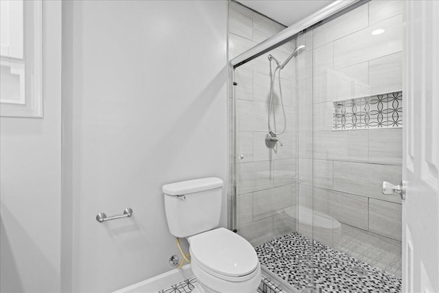 full bathroom with baseboards, a shower stall, and toilet