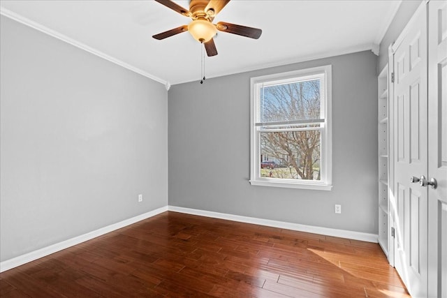 unfurnished bedroom featuring baseboards, wood finished floors, and crown molding