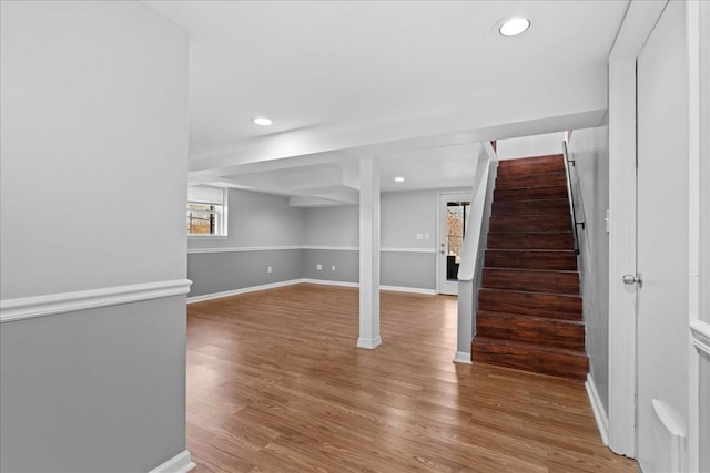 below grade area featuring baseboards, stairway, wood finished floors, and recessed lighting