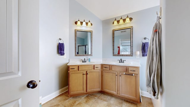 bathroom with tile patterned floors, a sink, baseboards, and double vanity