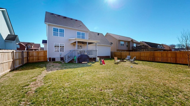 rear view of house with a fenced backyard, a deck, and a yard