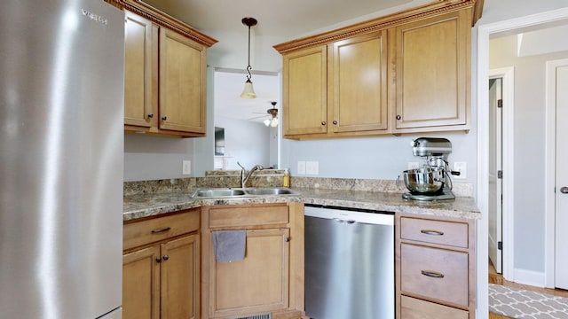 kitchen with appliances with stainless steel finishes, pendant lighting, light countertops, and a sink