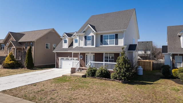 view of front of home with brick siding, covered porch, a front yard, fence, and driveway